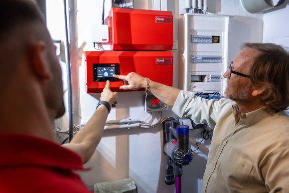 Dame bedient ihre Heizung über HovalConnect-App am Smartphone