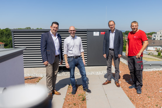 Das Projektteam vor der Hoval Belaria® pro (50) auf dem Dach von Slow Home Wien