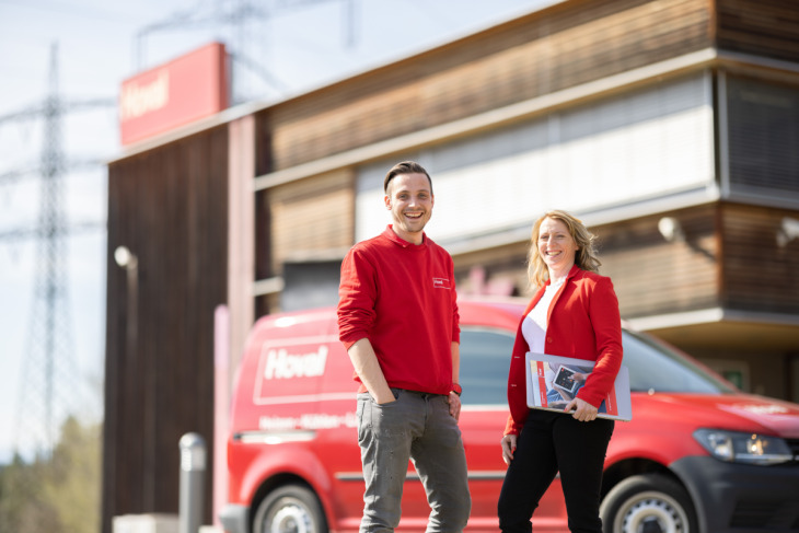 Fernwärme-Team von Hoval mit Auto & Gebäude von Hoval im Hintergrund