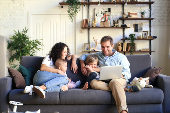 Familie genießt wohlige Wärme durch Fernwärme auf der Couch.