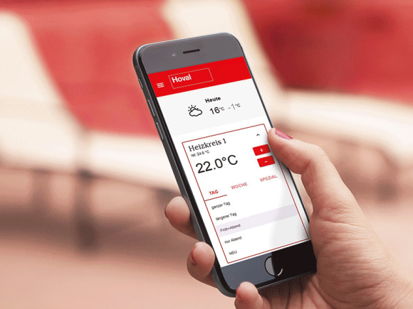 Bild zufriedener Besitzerin einer Hoval Hybridheizung. Gerade zeigt die Kundin die aktuellen Heizwerte auf Ihrem Smartphone.